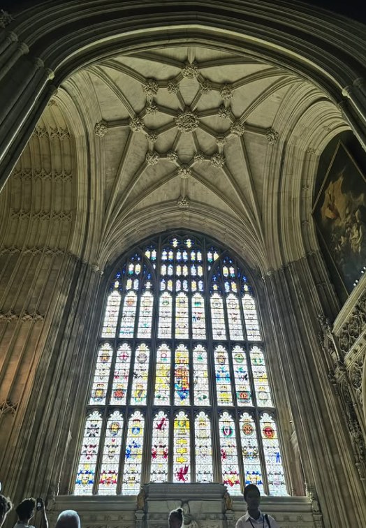 Heraldic glass in the great window above the Westminster Hall steps, seen from the floor of the hall with visitors below